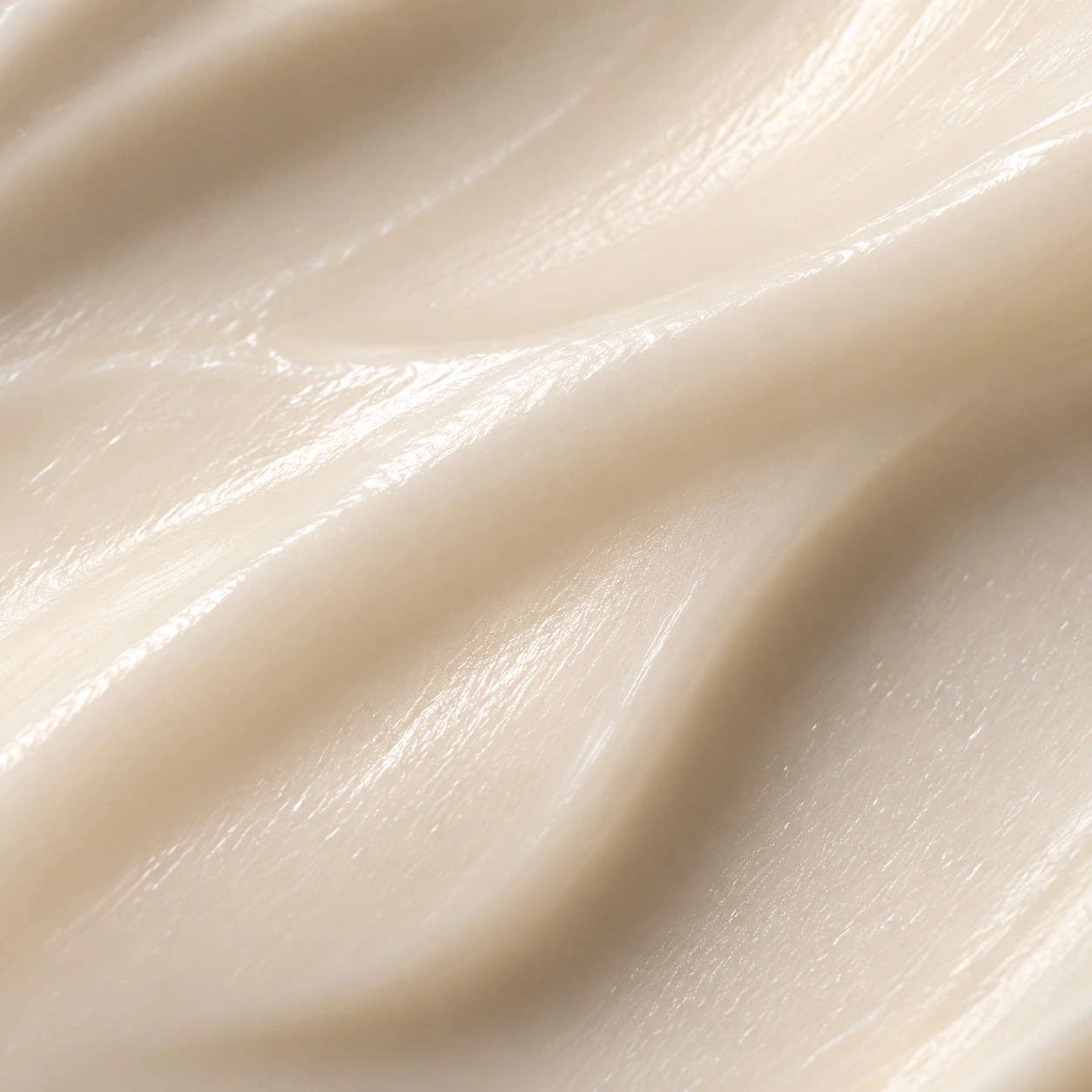 Close-up of a smooth ivory cream with soft satin folds